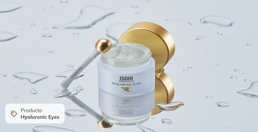 Contorno de ojos ISDIN Hyaluronic Eyes sobre fondo con gotas de agua, para hidratar y refrescar la mirada tras un día de playa