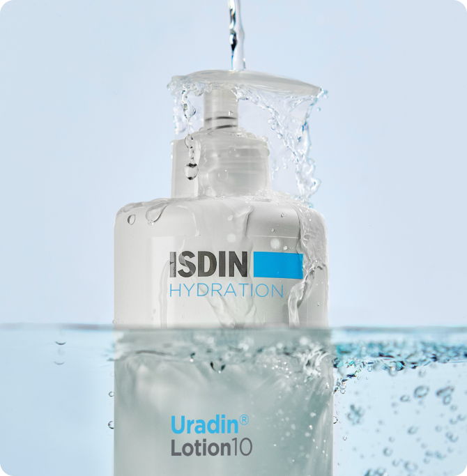 Loción corporal hidratante ISDIN Ureadin Lotion 10 bajo un chorro de agua, perfecta para reparar la piel tras la exposición solar