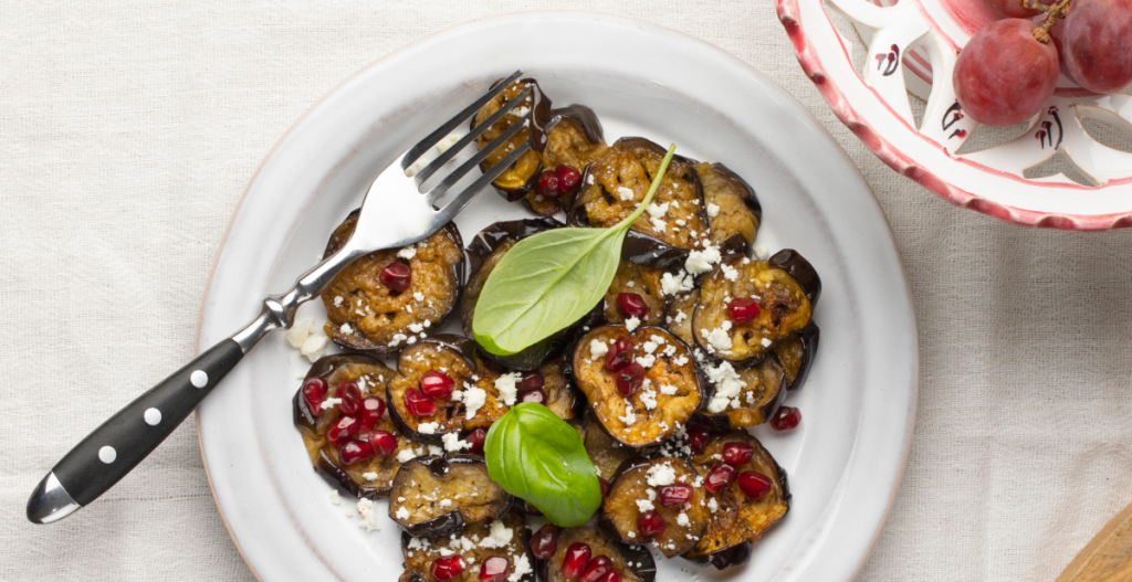 Plato saludable de verduras con granada, ejemplo de alimentación que favorece la piel