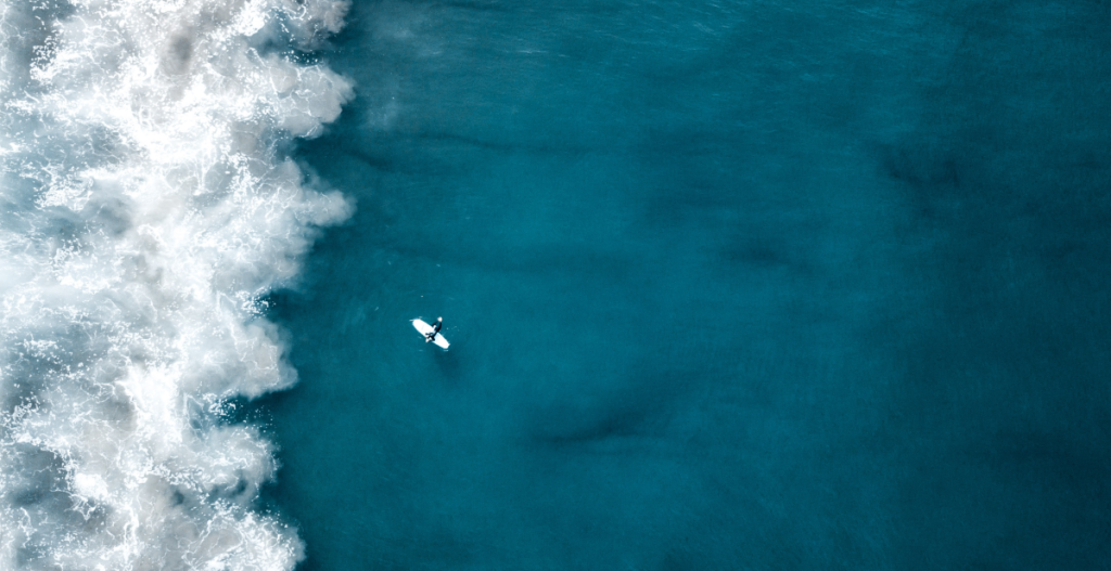 Vista aérea del océano Mediterráneo con un surfista, conexión entre personas y mar