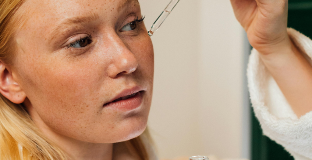 Mujer aplicando sérum facial con gotero, un paso clave en rutinas de skincare