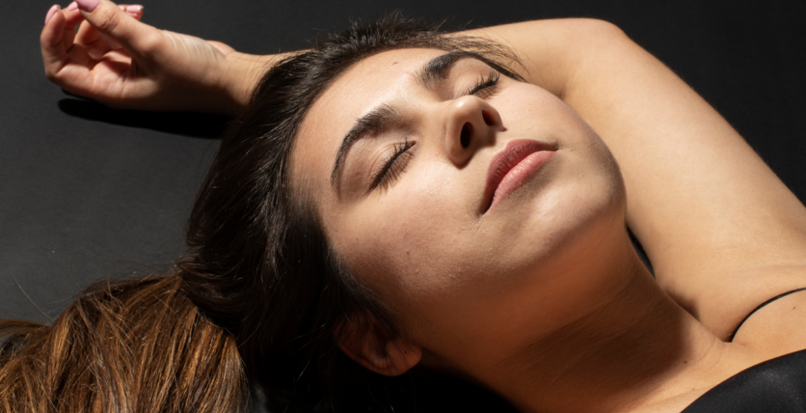 Mujer recostada con expresión relajada, asociada al bienestar y al skincare corporal enfocado en mantener el pH equilibrado