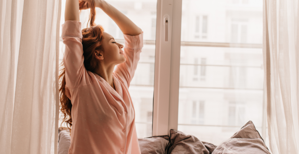 Mujer despertando por la mañana, simbolizando el inicio del ciclo diario de la piel y su función de protección durante el día.