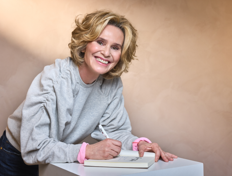 Dra. Marimer Pérez firmando ejemplares de su libro “No me sueltes” con una sonrisa cercana.