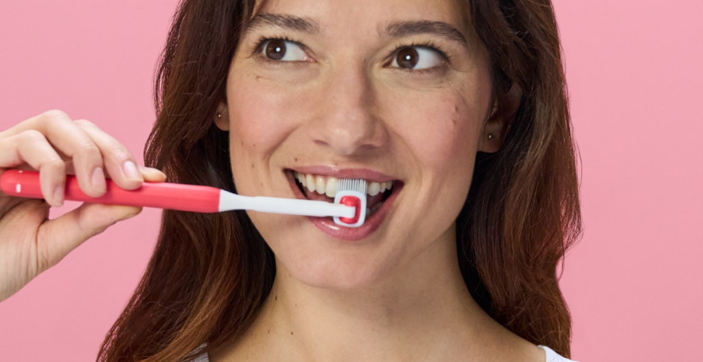 Mujer utilizando cepillo dental Balene de doble cara para limpiar dientes por dentro y por fuera