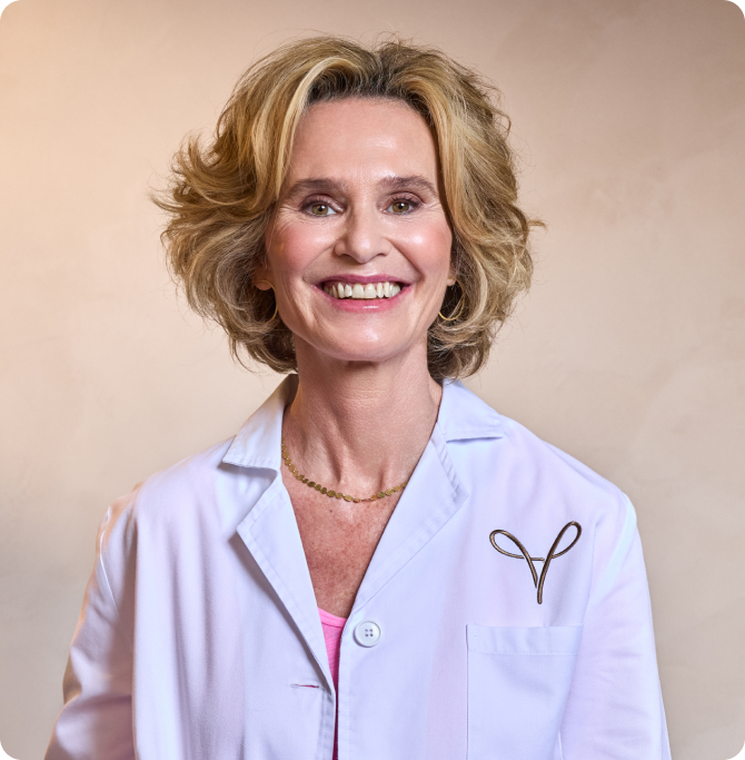 Retrato de la Dra. Marimer Pérez con bata médica blanca, sonriendo a cámara.