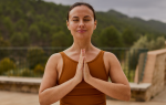 Profesora de yoga meditando al aire libre durante una sesión de yoga online en casa