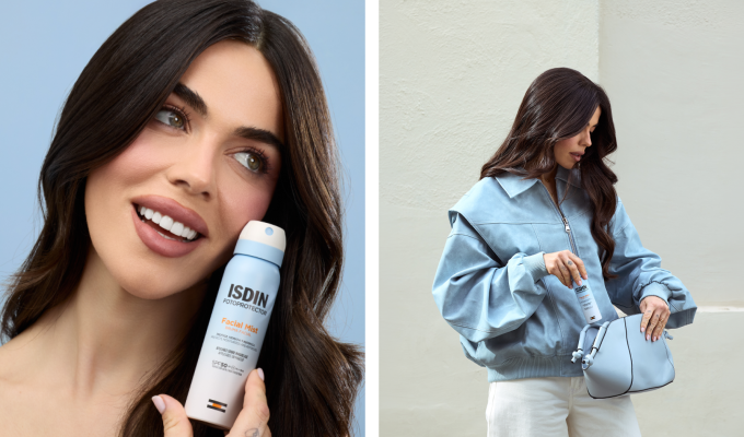 Violeta Mangriñan sosteniendo ISDIN Facial Mist SPF 50 junto al rostro y guardando el producto en un bolso azul.