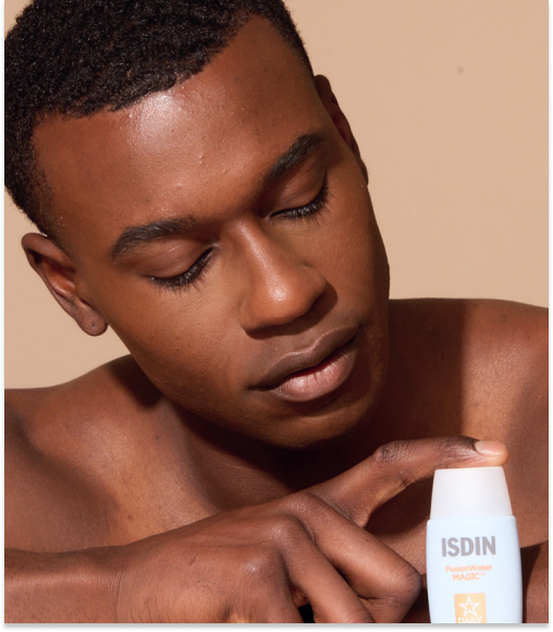 The man who applies sunscreen from a bottle of highlighted "Isdin Fusion Water Magic"pointing out the skin care application.