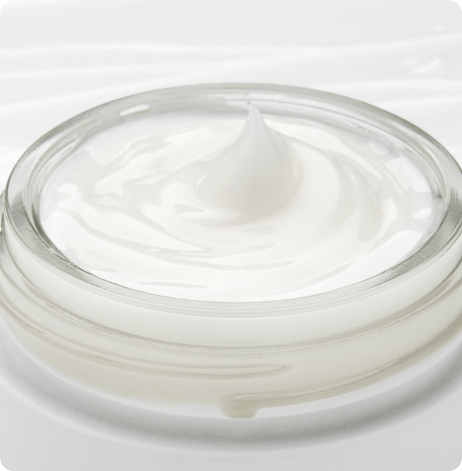Open jar of rich cream with smooth texture, ideal for nourishing winter skincare and protecting dry skin